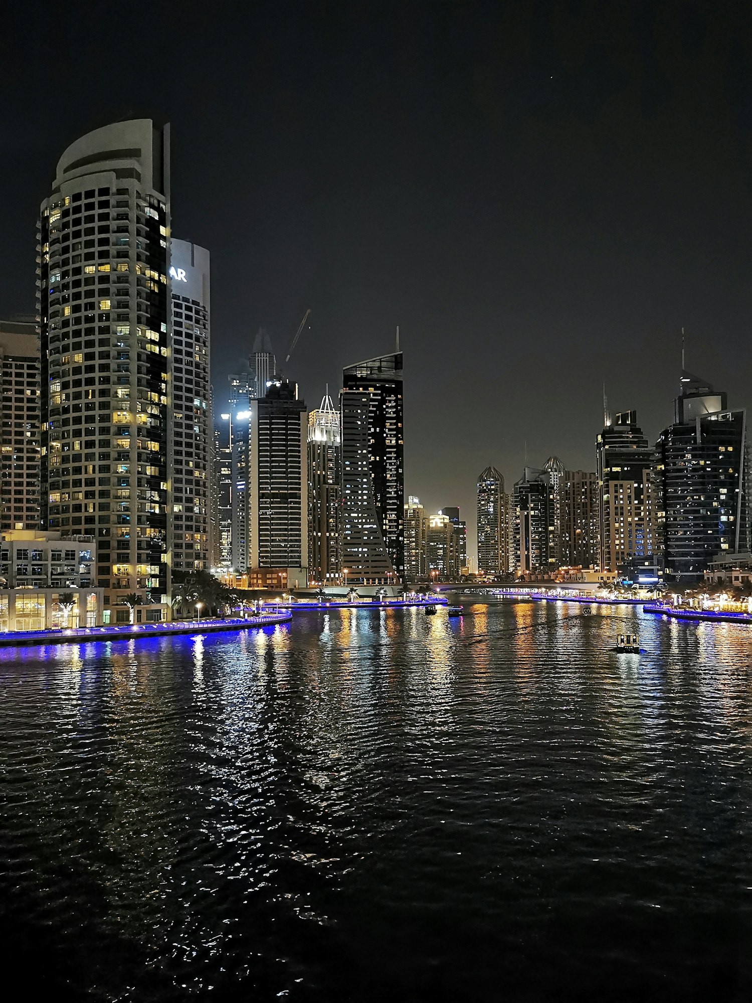 Skyscrapers are reflected in the water at night. JBR, UAE, Dubai Marina. Summer