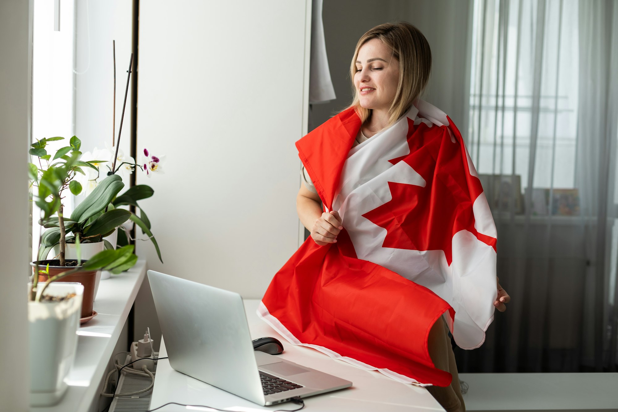 Young female student with Canadian flag and laptop with space for text